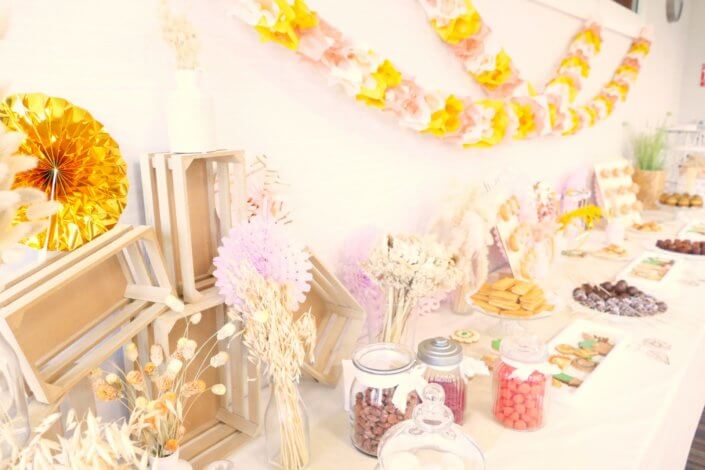 décoration colorée, avec des fleurs séchées, des rosaces, des guirlandes, des pâtisseries comme des cannelés, rochers coco, cupcakes, cakepops, sablés décorés, financiers et un candy bar