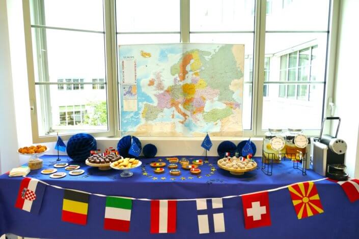 Goûter thème Europe pour l'ANCT avec sablés décorés drapeaux, boules de guimauve au chocolat, financiers, fontaines à boissons