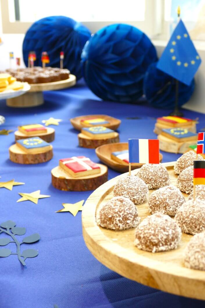 Goûter thème Europe pour l'ANCT avec sablés décorés drapeaux, boules de guimauve au chocolat, financiers, fontaines à boissons