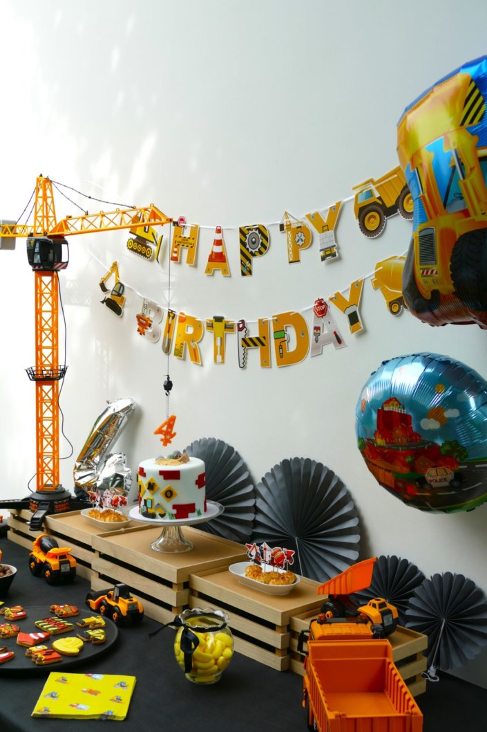 L'anniversaire chantier des 4 ans de Nino - décoration, ballons, nappe noire, pelleteuse avec boules de chocolat, sablés décorés engins de chantier, birthday cake