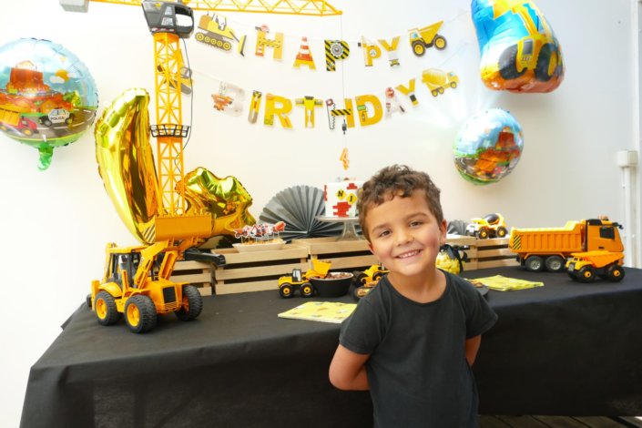 L'anniversaire chantier des 4 ans de Nino - décoration, ballons, nappe noire, pelleteuse avec boules de chocolat, sablés décorés engins de chantier, birthday cake