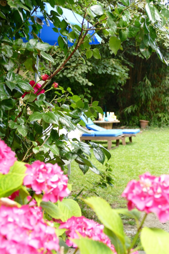 Pool party Uriage avec buffet décoré sur mesure de fleurs séchées, lanternes en bois, patisseries et sablés décorés en forme de crème solaire, cakepops, financiers, gâteaux