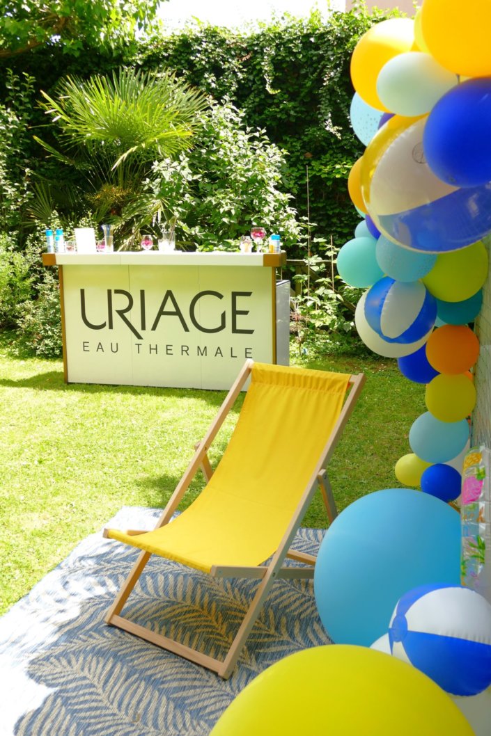 Pool party Uriage avec buffet décoré sur mesure de fleurs séchées, lanternes en bois, patisseries et sablés décorés en forme de crème solaire, cakepops, financiers, gâteaux