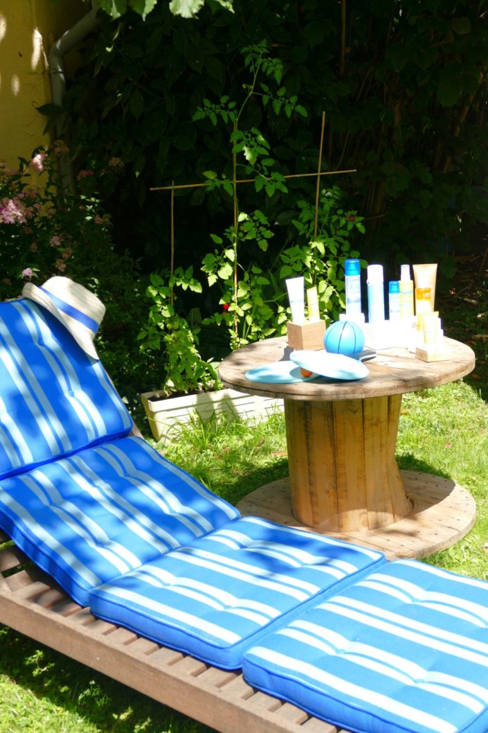 Pool party Uriage avec buffet décoré sur mesure de fleurs séchées, lanternes en bois, patisseries et sablés décorés en forme de crème solaire, cakepops, financiers, gâteaux