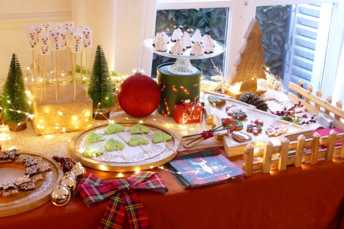 Table décorée Noël par Studio Candy pour la journée presse de Noël Zodio avec sablés décorés, sapins meringue, bonhommes de neige chamallows, couronne de sablés sur mesure, sapins brownie, et couronnes de charcuterie et fromages AOP, grazing cônes, verrines.