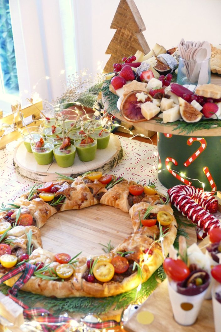 Table décorée Noël par Studio Candy pour la journée presse de Noël Zodio avec sablés décorés, sapins meringue, bonhommes de neige chamallows, couronne de sablés sur mesure, sapins brownie, et couronnes de charcuterie et fromages AOP, grazing cônes, verrines.