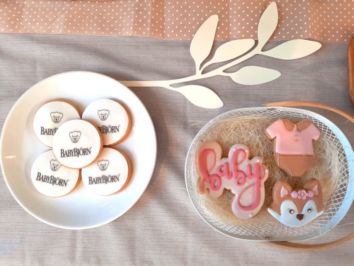 Goûter thème bébé dans les tons beige et rose poudré pour la nouvelle collection BabyBjorn : sablés décorés hochet, poussette, biberon, body, donuts, cakepops, fudge, financier et décoration