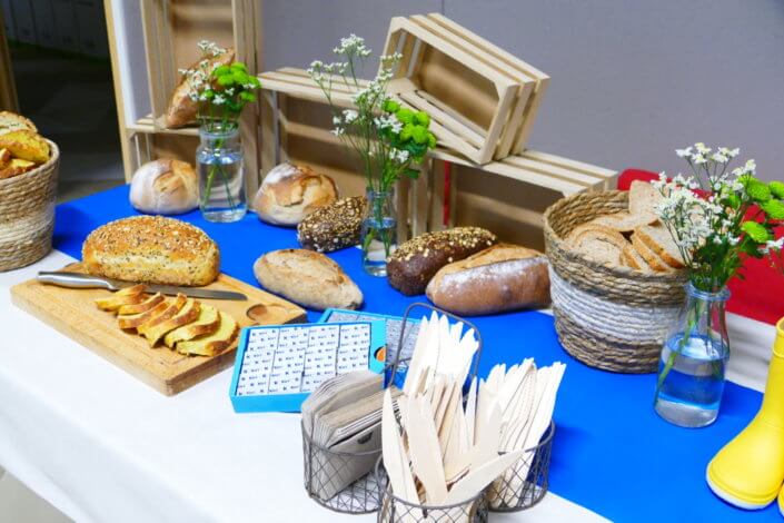 Table décorée pour Kiri avec petits sablés sur mesure : ferme, botte de foin, tracteur, vache, financiers, mini cannelés, brownie chocolat et bar à pain pour se tartiner son kiri ! Décoration champêtre enfantine avec de petites bottes fleuries, des fleurs des champs, des bottes de foin.