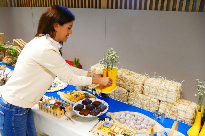 Table décorée pour Kiri avec petits sablés sur mesure : ferme, botte de foin, tracteur, vache, financiers, mini cannelés, brownie chocolat et bar à pain pour se tartiner son kiri ! Décoration champêtre enfantine avec de petites bottes fleuries, des fleurs des champs, des bottes de foin.