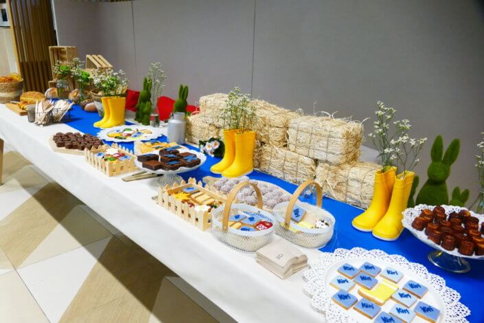 Table décorée pour Kiri avec petits sablés sur mesure : ferme, botte de foin, tracteur, vache, financiers, mini cannelés, brownie chocolat et bar à pain pour se tartiner son kiri ! Décoration champêtre enfantine avec de petites bottes fleuries, des fleurs des champs, des bottes de foin.