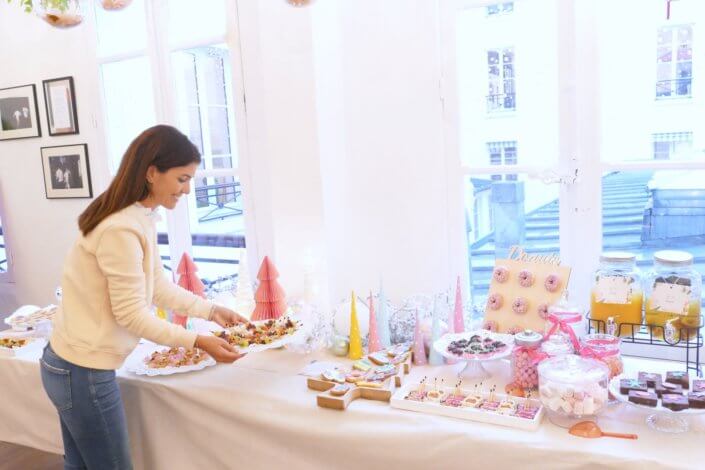 Table de Noël pour la soirée influence des parfums Adopt' - Décoration en blanc et rose, sablés décorés de Noël sur mesure, financiers, brownie, fontaines à boissons et pièces salées roses sur mesure.