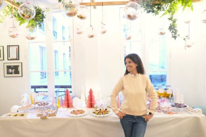 Table de Noël pour la soirée influence des parfums Adopt' - Décoration en blanc et rose, sablés décorés de Noël sur mesure, financiers, brownie, fontaines à boissons et pièces salées roses sur mesure.