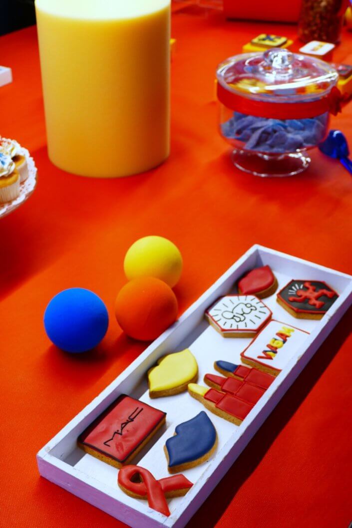 Table décorée pour la campagne M.A.C Viva Glam par Studio Candy - Candy Bar bleu, rouge et jaune, pâtisseries sur mesure Keith Haring