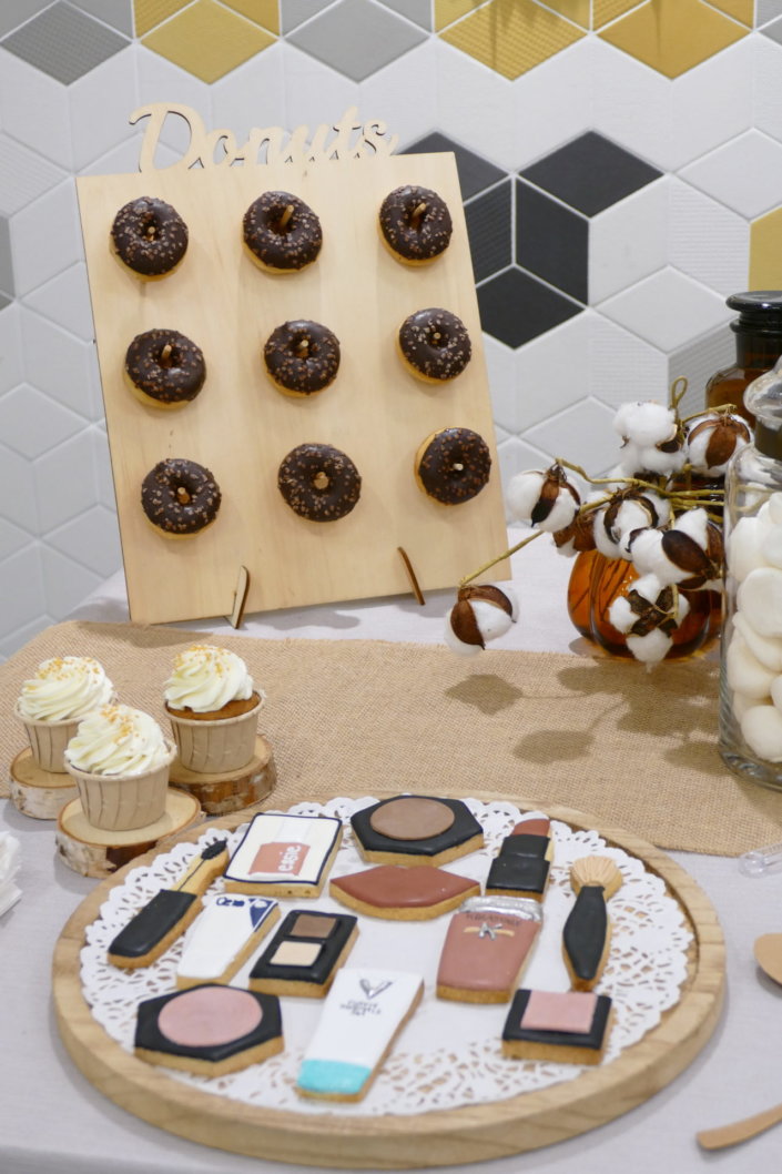 remise des médailles chez L'Oréal avec une table de goûter sur mesure réalisée par Studio Candy tout en or, bois et beige avec des sablés décorés Kerastase, Vichy, vernis Essie, crème CeraVe