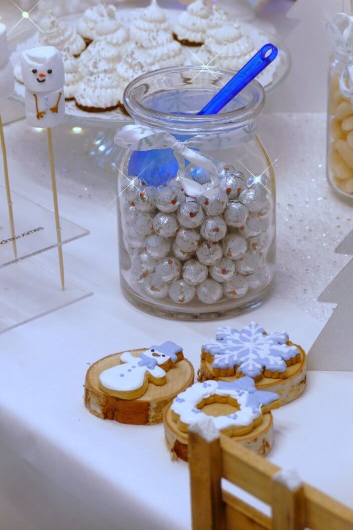 Goûter de Noël Polaire avec mini cupcakes, cakepops, brochettes de chamallows, candybar, boissons, décoration hiver polaire en blanc, argent et bleu glacier