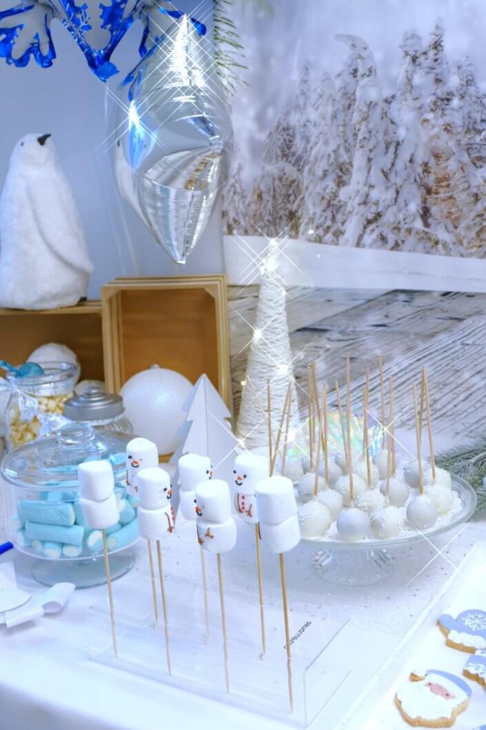 Goûter de Noël Polaire avec mini cupcakes, cakepops, brochettes de chamallows, candybar, boissons, décoration hiver polaire en blanc, argent et bleu glacier