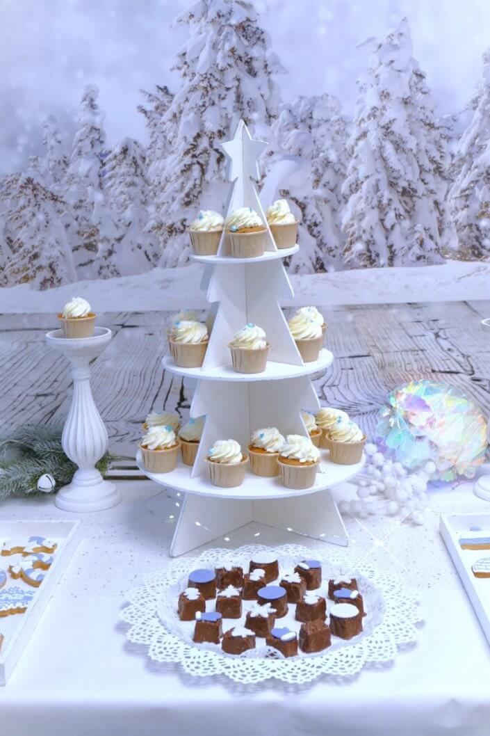 Goûter de Noël Polaire avec mini cupcakes, cakepops, brochettes de chamallows, candybar, boissons, décoration hiver polaire en blanc, argent et bleu glacier