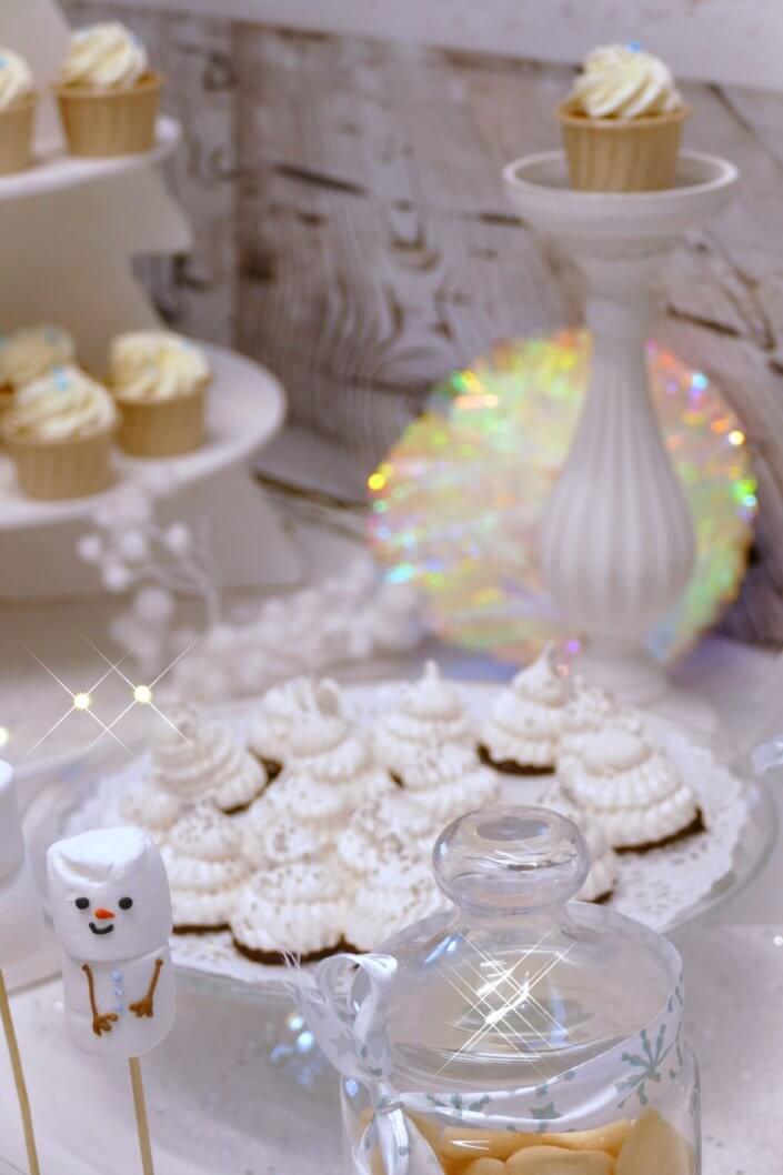 Goûter de Noël Polaire avec mini cupcakes, cakepops, brochettes de chamallows, candybar, boissons, décoration hiver polaire en blanc, argent et bleu glacier