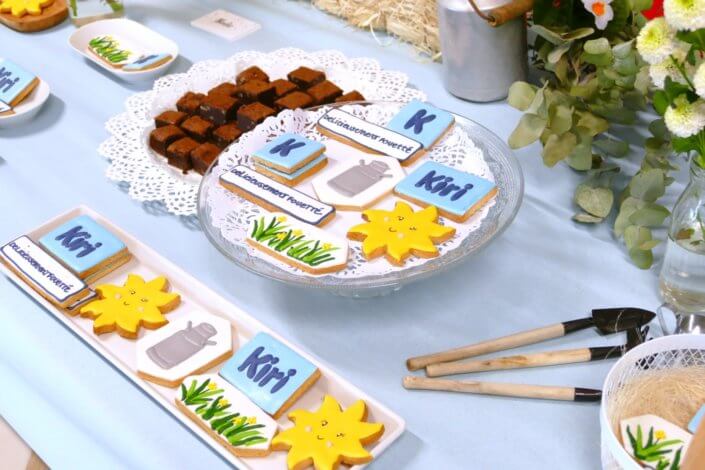 lancement nouveau kiri avec une table sur mesure : sablés décorés kiri, bottes de foin, brownie au chocolat, fleurs fraîches, financiers