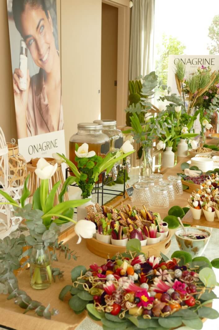 Journée presse Noreva avec une table nature et printanière par Studio Candy avec sablés décorés feuillage, financier, brownie aux noix, granola, verrines, brochettes de fruits et crudités, grazing cônes et décoration green nature de tulipe, eucalyptus et fleurs fraîches