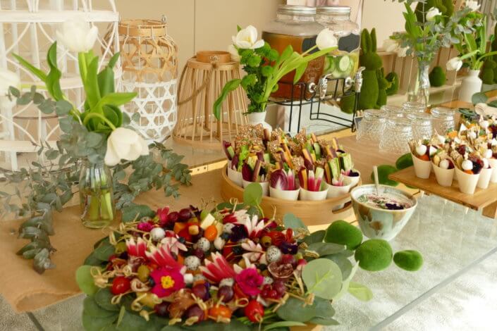 Journée presse Noreva avec une table nature et printanière par Studio Candy avec sablés décorés feuillage, financier, brownie aux noix, granola, verrines, brochettes de fruits et crudités, grazing cônes et décoration green nature de tulipe, eucalyptus et fleurs fraîches