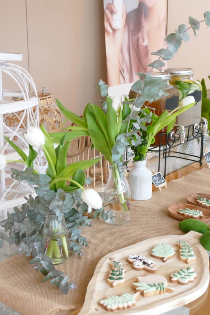 Journée presse Noreva avec une table nature et printanière par Studio Candy avec sablés décorés feuillage, financier, brownie aux noix, granola, verrines, brochettes de fruits et crudités, grazing cônes et décoration green nature de tulipe, eucalyptus et fleurs fraîches