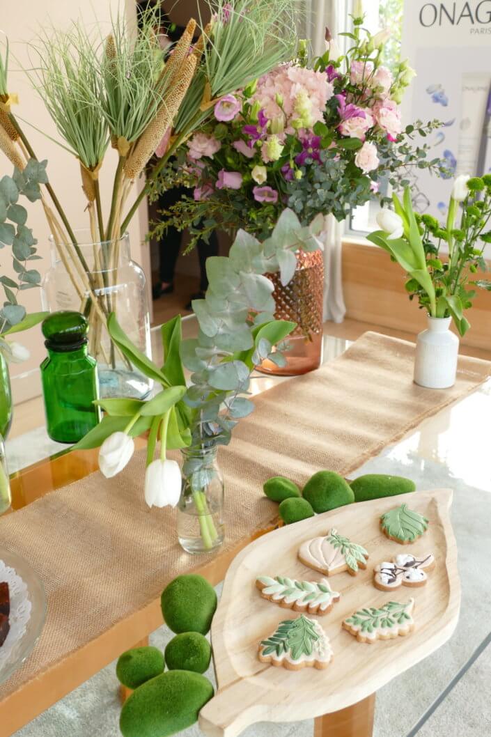 Journée presse Noreva avec une table nature et printanière par Studio Candy avec sablés décorés feuillage, financier, brownie aux noix, granola, verrines, brochettes de fruits et crudités, grazing cônes et décoration green nature de tulipe, eucalyptus et fleurs fraîches