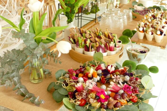 Journée presse Noreva avec une table nature et printanière par Studio Candy avec sablés décorés feuillage, financier, brownie aux noix, granola, verrines, brochettes de fruits et crudités, grazing cônes et décoration green nature de tulipe, eucalyptus et fleurs fraîches