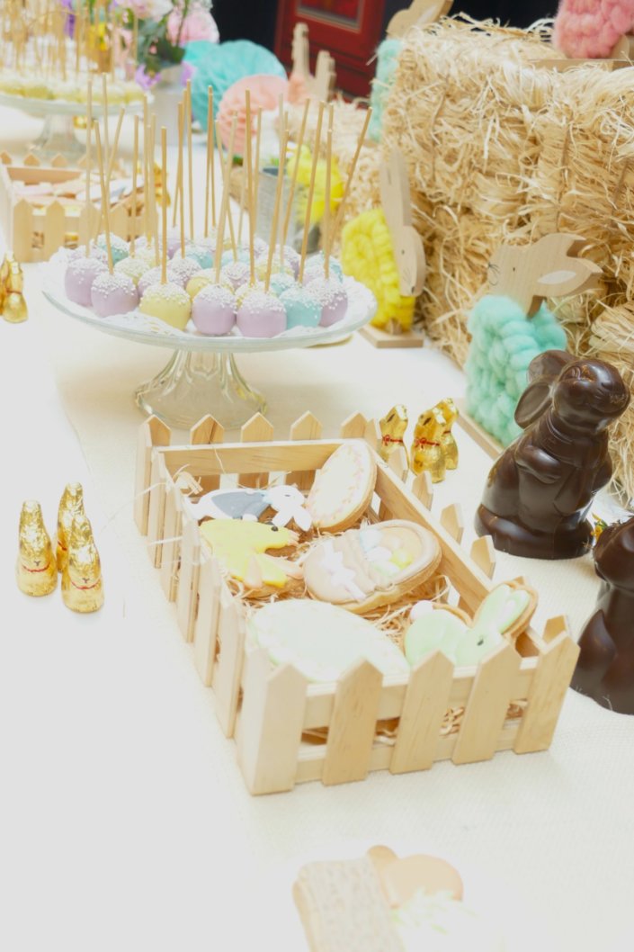 Goûter de Pâques avec oeufs en chocolat, carrot cake, cake marbré vanille chocolat, cakepops, fruits, financiers, roses des sables, sablés décorés, décoration bottes de foin et fleurs fraîches par STUDIO CANDY