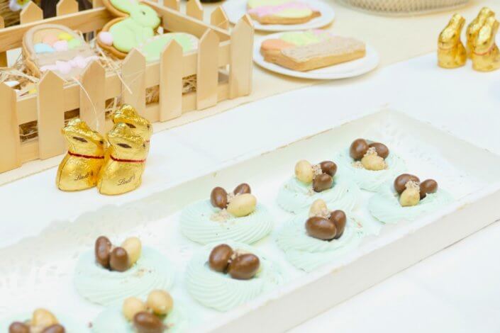 Goûter de Pâques avec oeufs en chocolat, carrot cake, cake marbré vanille chocolat, cakepops, fruits, financiers, roses des sables, sablés décorés, décoration bottes de foin et fleurs fraîches par STUDIO CANDY