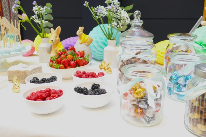 Goûter de Pâques avec oeufs en chocolat, carrot cake, cake marbré vanille chocolat, cakepops, fruits, financiers, roses des sables, sablés décorés, décoration bottes de foin et fleurs fraîches par STUDIO CANDY