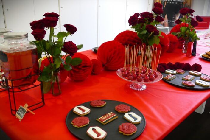 Lancement du parfum Very Good Girl de Carolina Herrera avec Studio Candy : table sur mesure avec des sablés décorés, cakepops rouges pailletés, madeleines, brownie, nappage rouge, bouquets de roses rouges