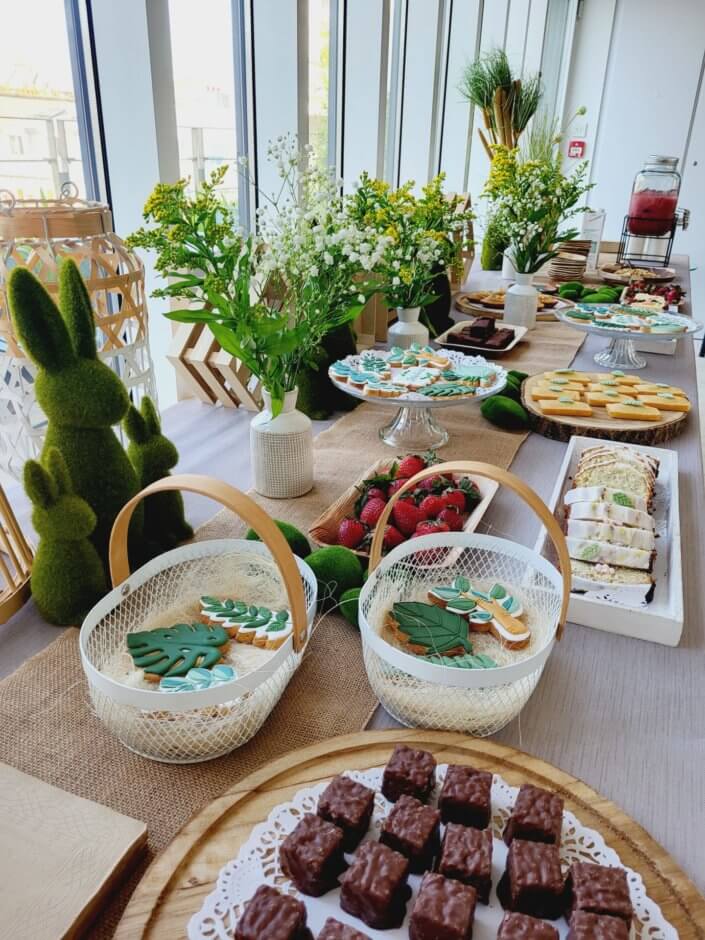 petit déjeuner healthy sur mesure par studio candy chez Hermès avec sablés décorés, carrot cake, fraises, granola, madeleines noisette, bouquets fleuris printaniers, fontaines à boissons de smoothie fraise et jus vert détox. Décoration nature, douce et fleurie.