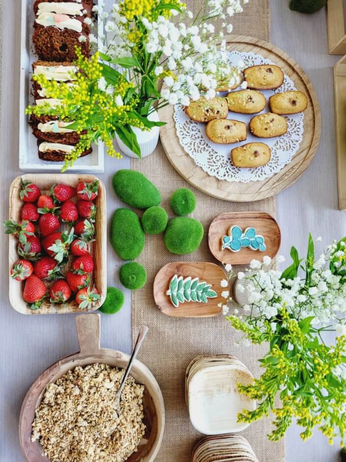 petit déjeuner healthy sur mesure par studio candy chez Hermès avec sablés décorés, carrot cake, fraises, granola, madeleines noisette, bouquets fleuris printaniers, fontaines à boissons de smoothie fraise et jus vert détox. Décoration nature, douce et fleurie.