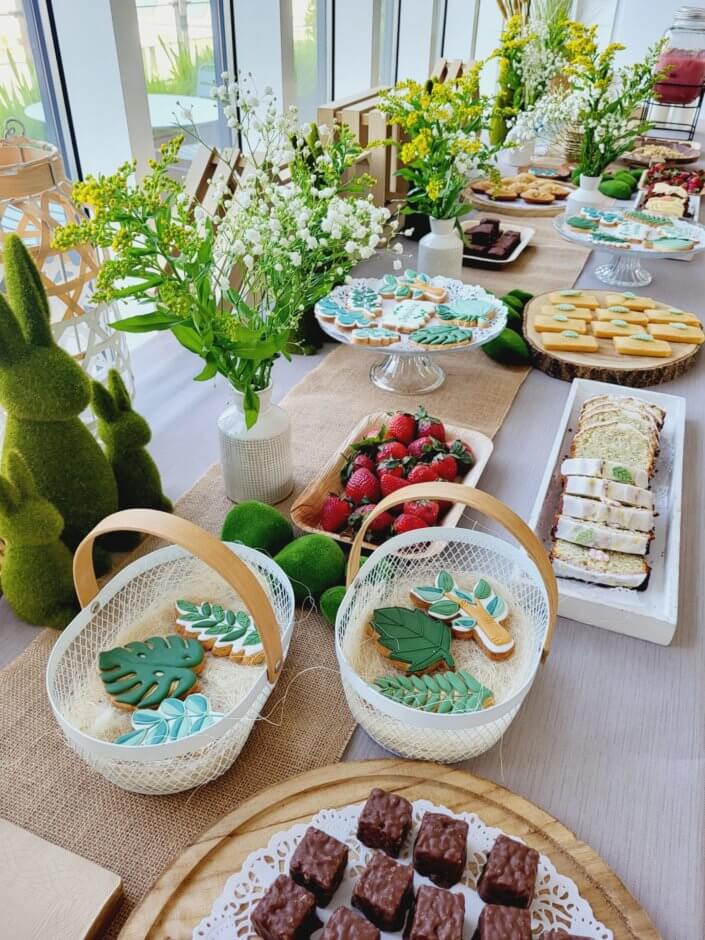 petit déjeuner healthy sur mesure par studio candy chez Hermès avec sablés décorés, carrot cake, fraises, granola, madeleines noisette, bouquets fleuris printaniers, fontaines à boissons de smoothie fraise et jus vert détox. Décoration nature, douce et fleurie.