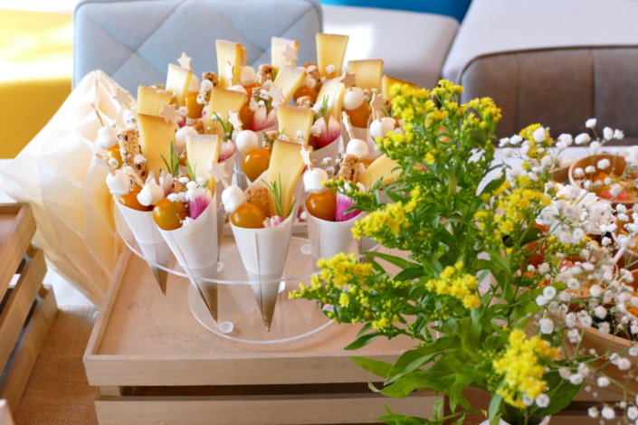 Jolie table thème mariage avec petites brochettes, salades, planche de fromages, feuilletés, sablés décorés wedding day, financiers, décoration or, blanc et petits bouquets de gypsophille