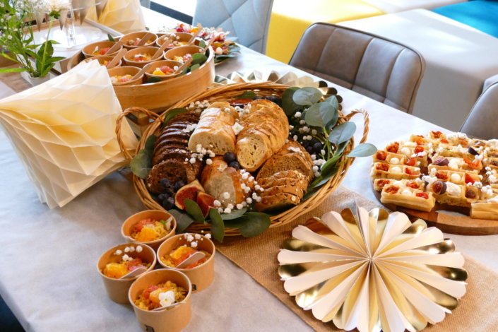 Jolie table thème mariage avec petites brochettes, salades, planche de fromages, feuilletés, sablés décorés wedding day, financiers, décoration or, blanc et petits bouquets de gypsophille