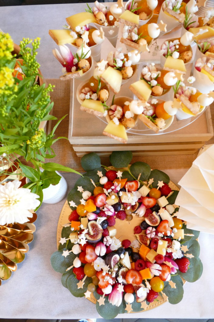 Jolie table thème mariage avec petites brochettes, salades, planche de fromages, feuilletés, sablés décorés wedding day, financiers, décoration or, blanc et petits bouquets de gypsophille