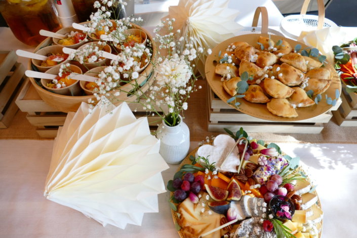 Jolie table thème mariage avec petites brochettes, salades, planche de fromages, feuilletés, sablés décorés wedding day, financiers, décoration or, blanc et petits bouquets de gypsophille