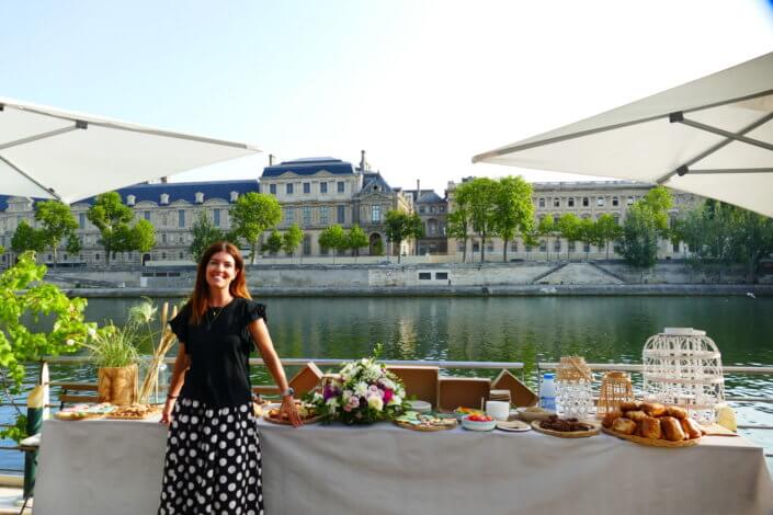 Petit déjeuner sur une péniche face au Louvre par studio Candy : beignets, financiers, sablés décorés, granola, fruits frais et décoration estivale