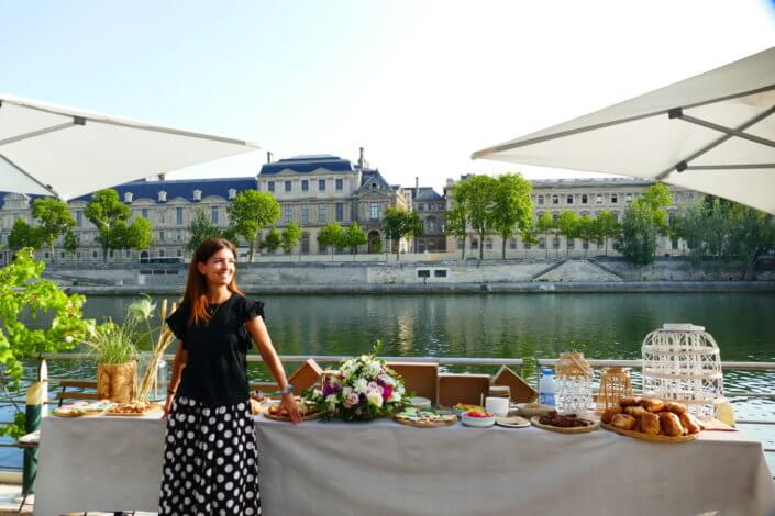 Petit déjeuner sur une péniche face au Louvre par studio Candy : beignets, financiers, sablés décorés, granola, fruits frais et décoration estivale