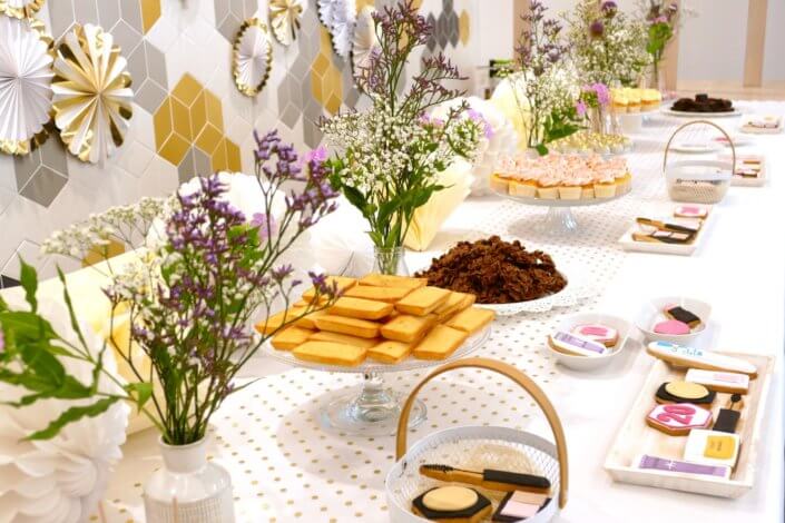 Goûter sur mesure pour la remise des médailles du travail chez L'Oréal par Studio Candy avec sablés décorés makeup, cakepops et cupcakes pailletés, mur de rosaces, bouquets de fleurs