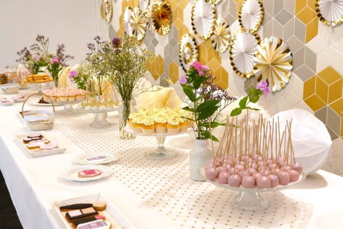 Goûter sur mesure pour la remise des médailles du travail chez L'Oréal par Studio Candy avec sablés décorés makeup, cakepops et cupcakes pailletés, mur de rosaces, bouquets de fleurs
