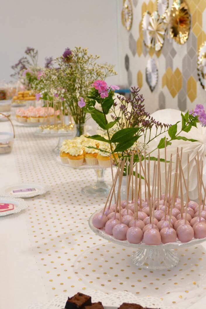 Goûter sur mesure pour la remise des médailles du travail chez L'Oréal par Studio Candy avec sablés décorés makeup, cakepops et cupcakes pailletés, mur de rosaces, bouquets de fleurs