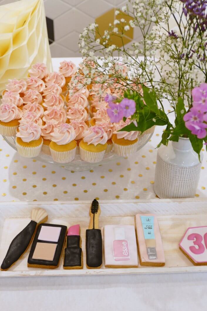 Goûter sur mesure pour la remise des médailles du travail chez L'Oréal par Studio Candy avec sablés décorés makeup, cakepops et cupcakes pailletés, mur de rosaces, bouquets de fleurs