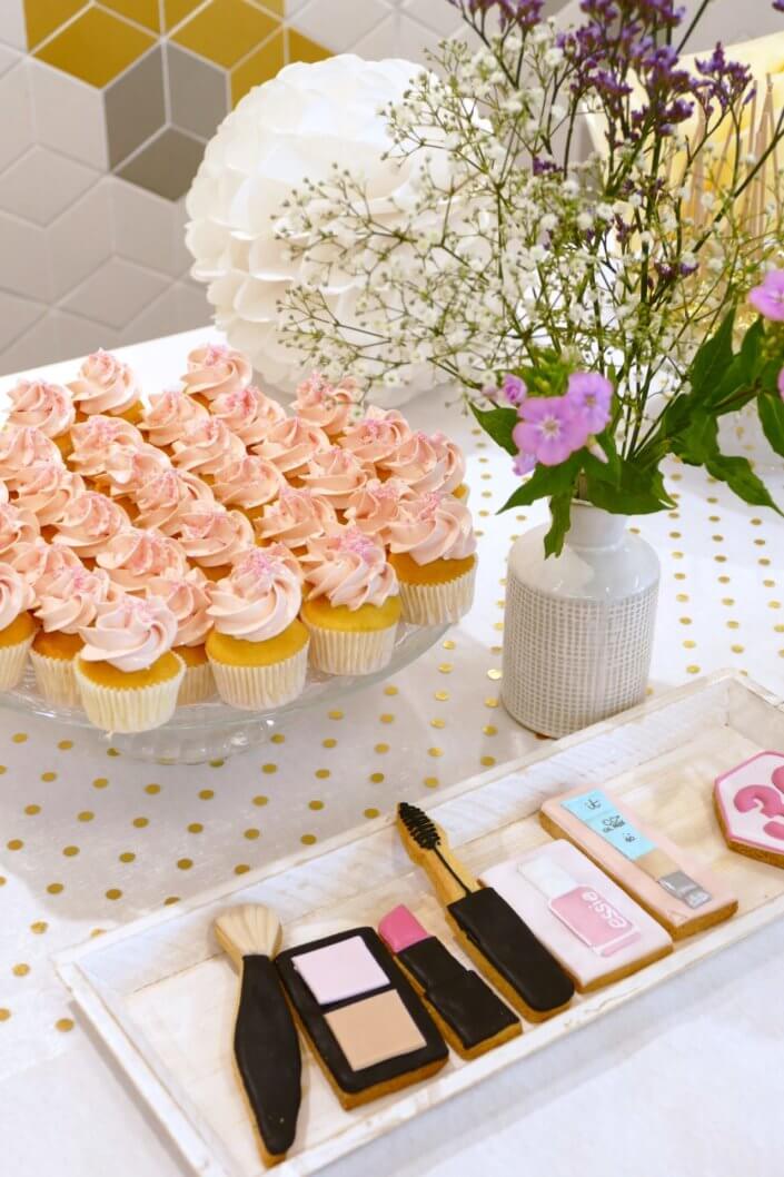 Goûter sur mesure pour la remise des médailles du travail chez L'Oréal par Studio Candy avec sablés décorés makeup, cakepops et cupcakes pailletés, mur de rosaces, bouquets de fleurs