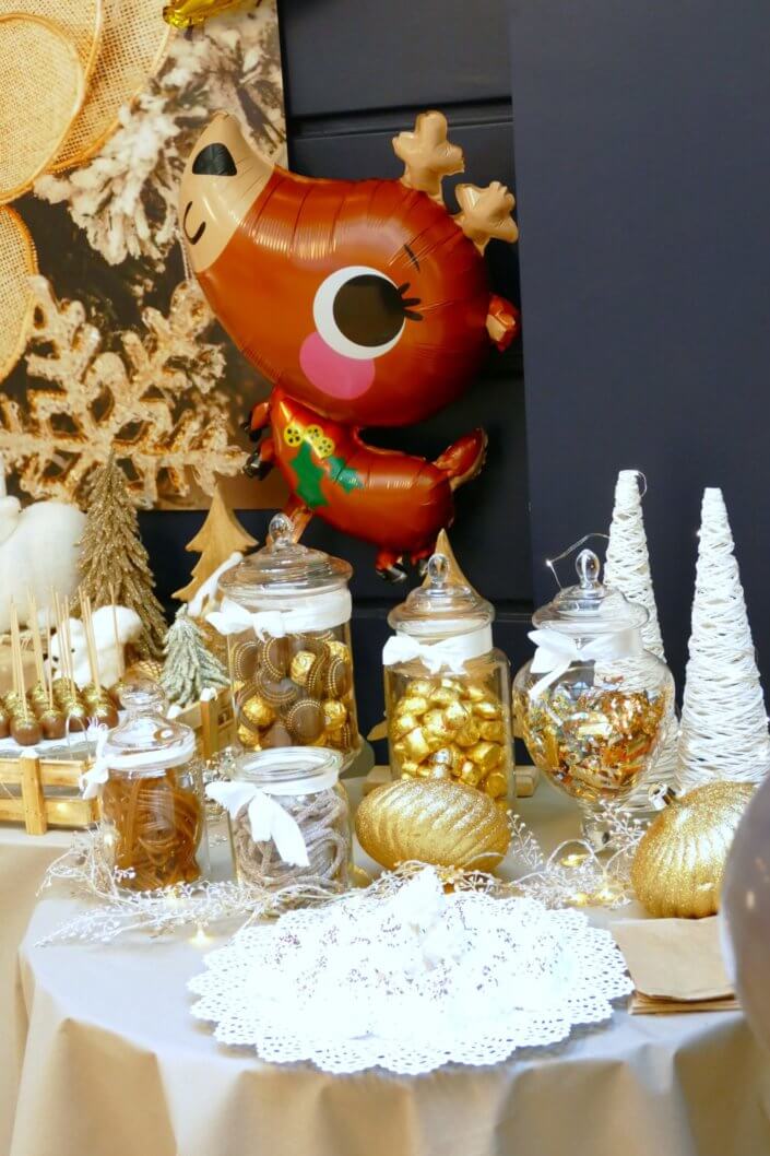 Noel nature par studio candy avec une décoration en beige et doré, des cakepops au chocolat, des mini cupcakes, des sablés décorés de Noël, un candy bar de chocolats et des ballons mignons pour les enfants