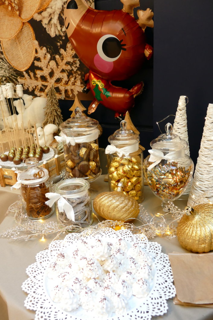 Noel nature par studio candy avec une décoration en beige et doré, des cakepops au chocolat, des mini cupcakes, des sablés décorés de Noël, un candy bar de chocolats et des ballons mignons pour les enfants