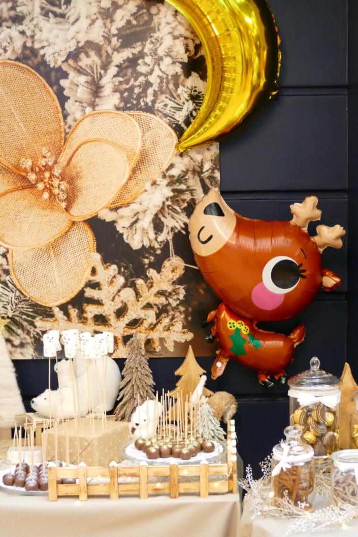 Noel nature par studio candy avec une décoration en beige et doré, des cakepops au chocolat, des mini cupcakes, des sablés décorés de Noël, un candy bar de chocolats et des ballons mignons pour les enfants