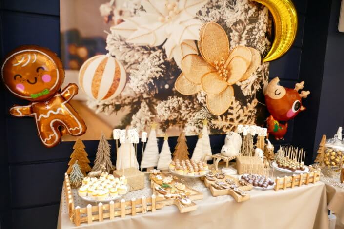 Noel nature par studio candy avec une décoration en beige et doré, des cakepops au chocolat, des mini cupcakes, des sablés décorés de Noël, un candy bar de chocolats et des ballons mignons pour les enfants